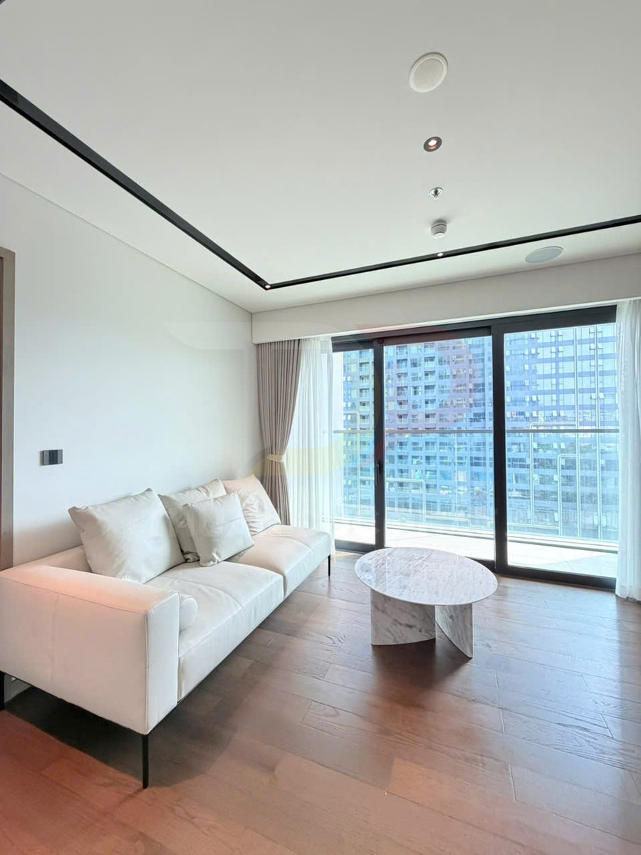 Sofa vải màu trắng và bàn trà mặt đá cẩm thạch trong phòng khách chung cư hiện đại có cửa kính lớn
