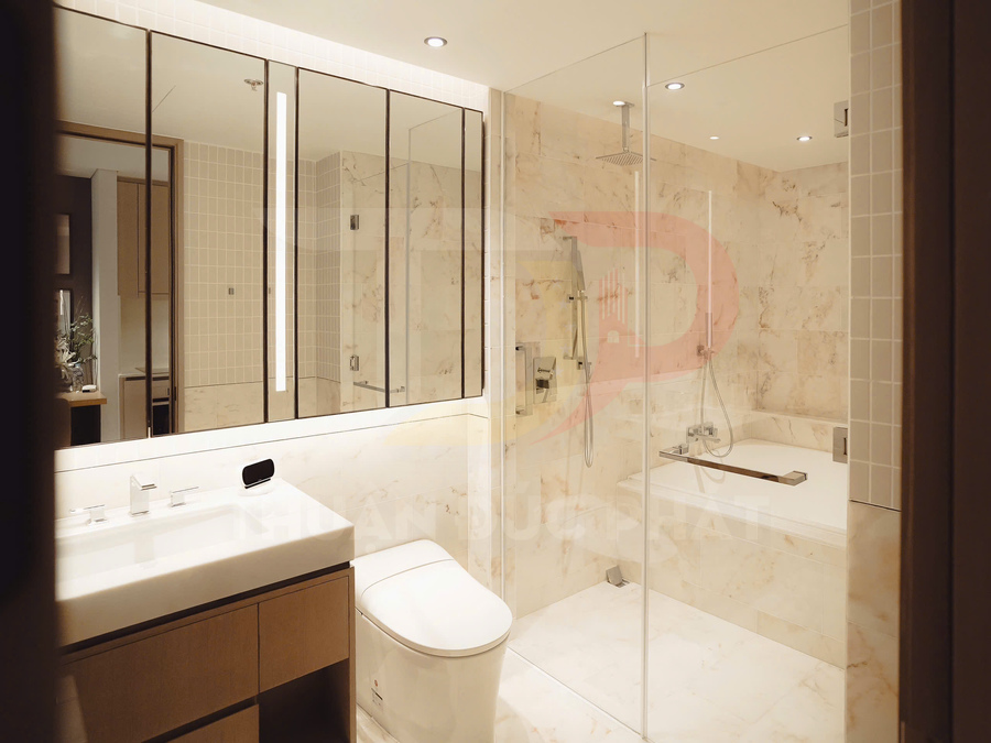 Phòng tắm hiện đại với bồn tắm kính, vòi sen âm tường, bồn cầu và lavabo mặt đá sáng màu