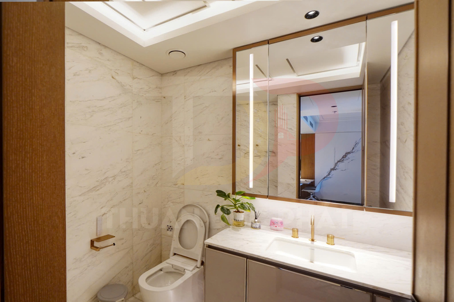 Phòng tắm hiện đại với bồn cầu, bồn rửa mặt đá cẩm thạch và tủ gương có đèn LED dọc