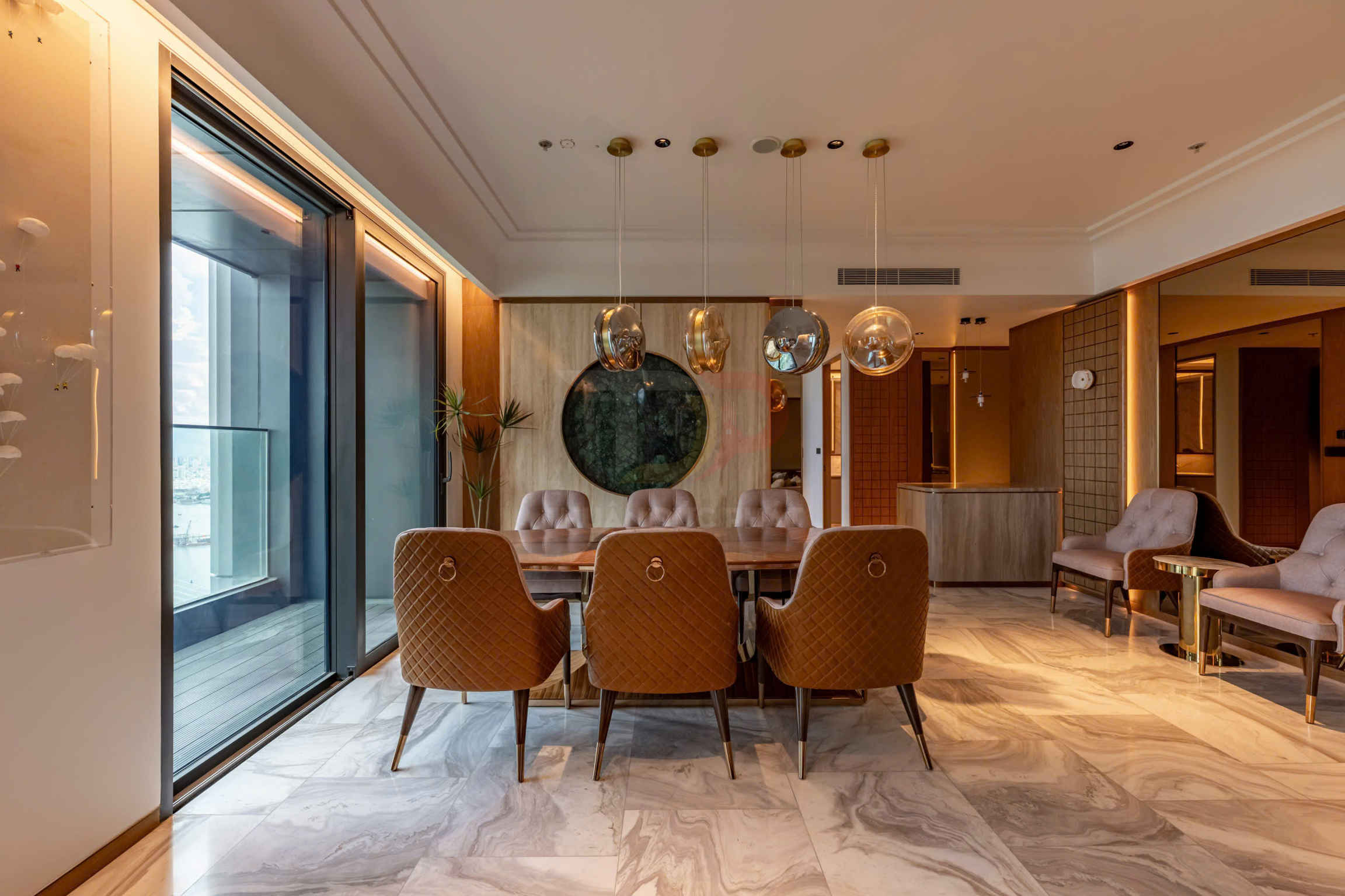 Bàn ăn gỗ với ghế bọc da nâu sang trọng trong phòng khách hiện đại lát đá marble có cửa kính lớn