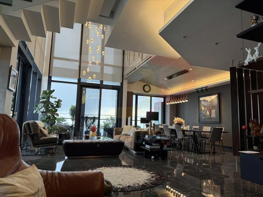 Phòng khách và phòng ăn chung cư cao cấp với sofa da, bàn ăn hiện đại và cửa kính lớn nhìn ra ban công