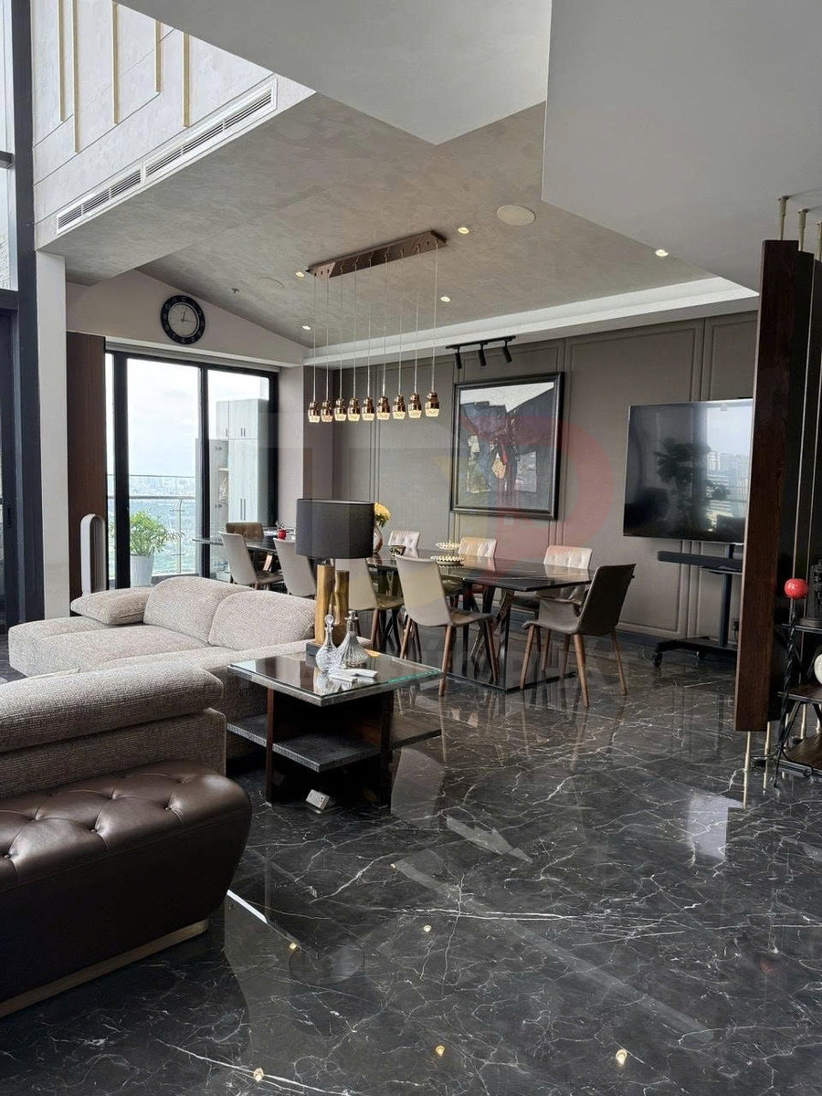 Phòng khách và phòng ăn hiện đại với sofa vải, bàn kính và sàn gạch đá hoa cương bóng cao cấp