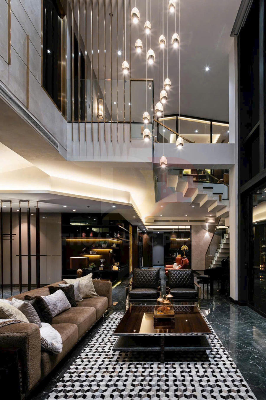 Phòng khách sang trọng với sofa nâu, bàn trà kính, ghế da đen và đèn thả trần hiện đại trong không gian thông tầng