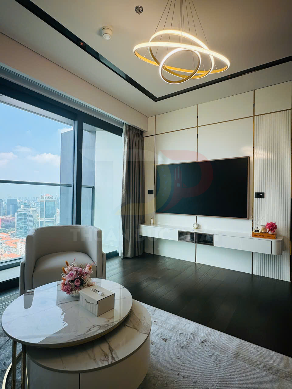 Đèn chùm LED vòng tròn hiện đại treo trần trong phòng khách chung cư sang trọng có cửa kính lớn