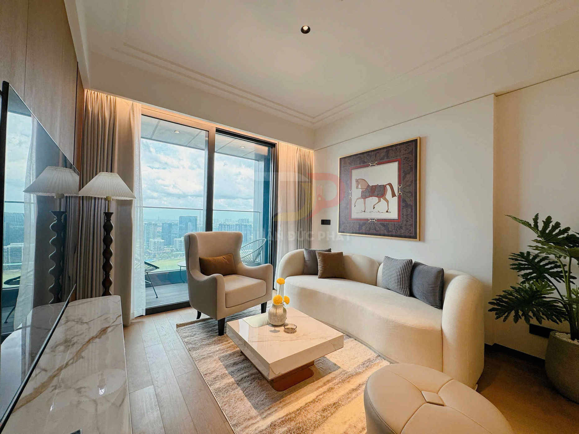 Phòng khách chung cư cao cấp với sofa cong màu kem, bàn trà đá và cửa kính lớn nhìn ra thành phố