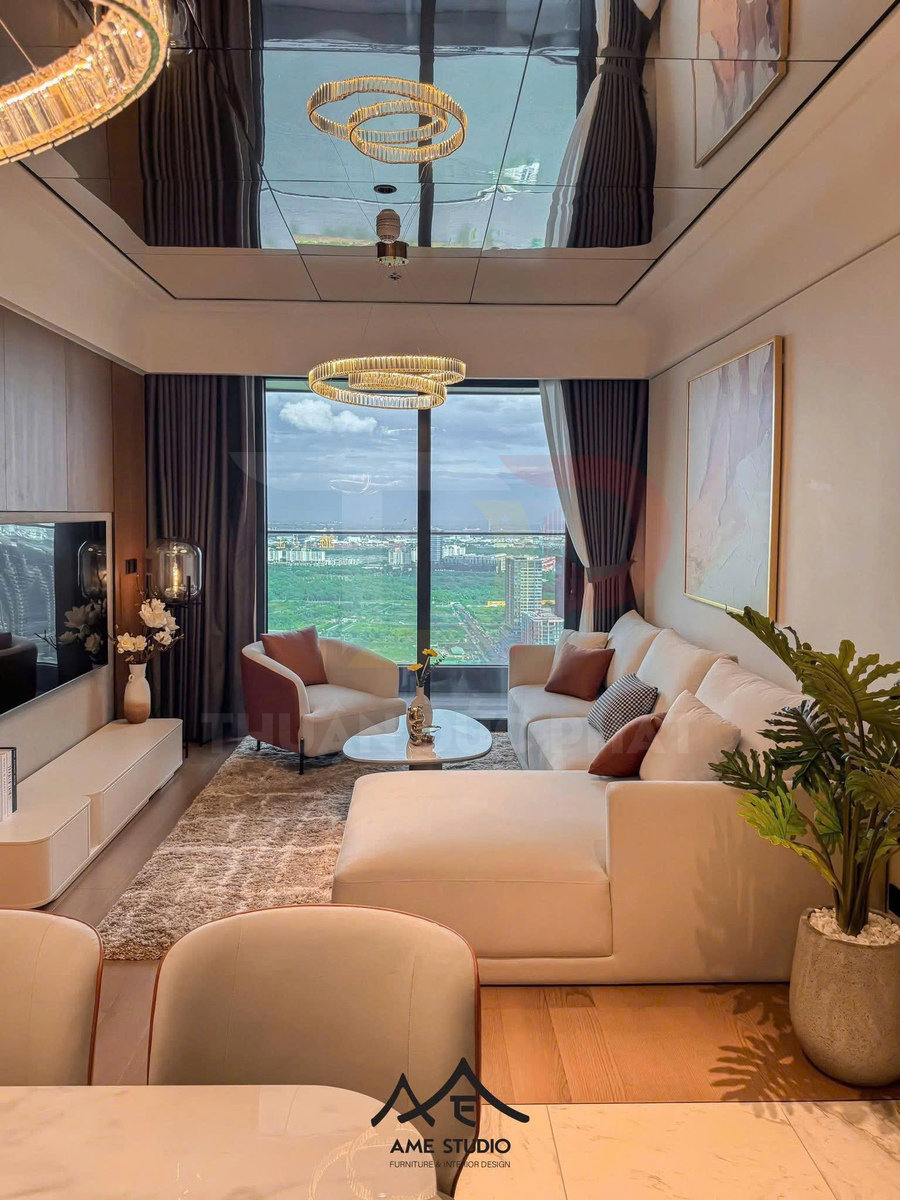 Phòng khách chung cư hiện đại với sofa chữ L màu trắng, bàn trà đá, đèn trần vòng tròn và cửa kính lớn nhìn ra thành phố