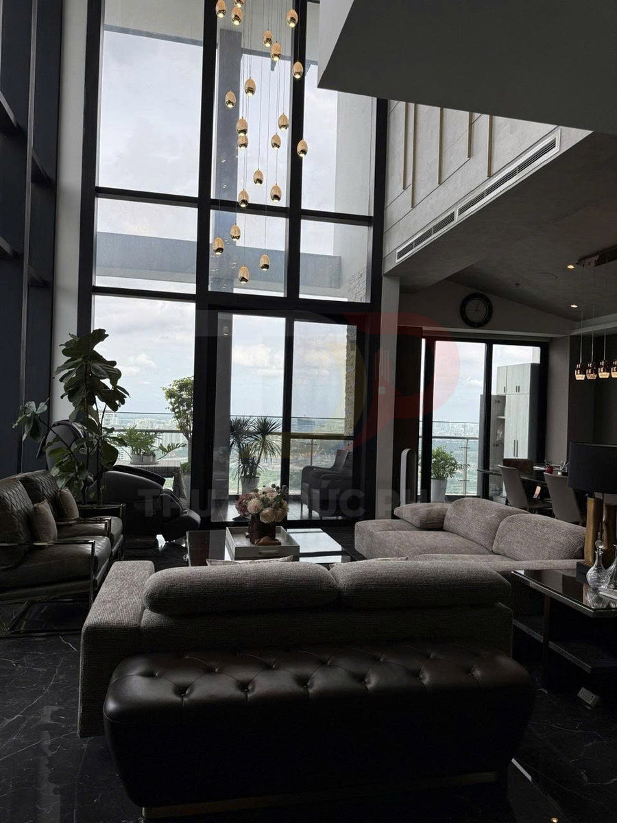 Phòng khách chung cư cao cấp với sofa hiện đại, bàn trà kính và cửa kính lớn nhìn ra ban công biển