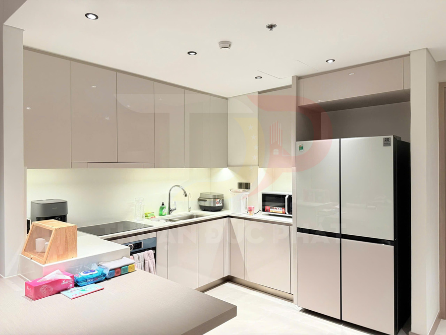 Gian bếp hiện đại với tủ bếp chữ L, bồn rửa inox, lò vi sóng và tủ lạnh side by side màu bạc