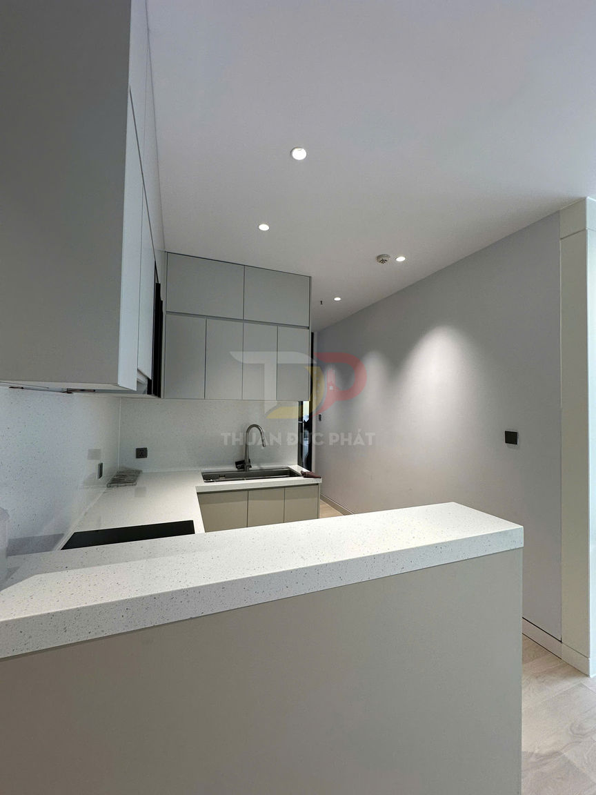 Bếp nhỏ hiện đại với tủ bếp âm tường màu xám và mặt bàn đá thạch anh trắng