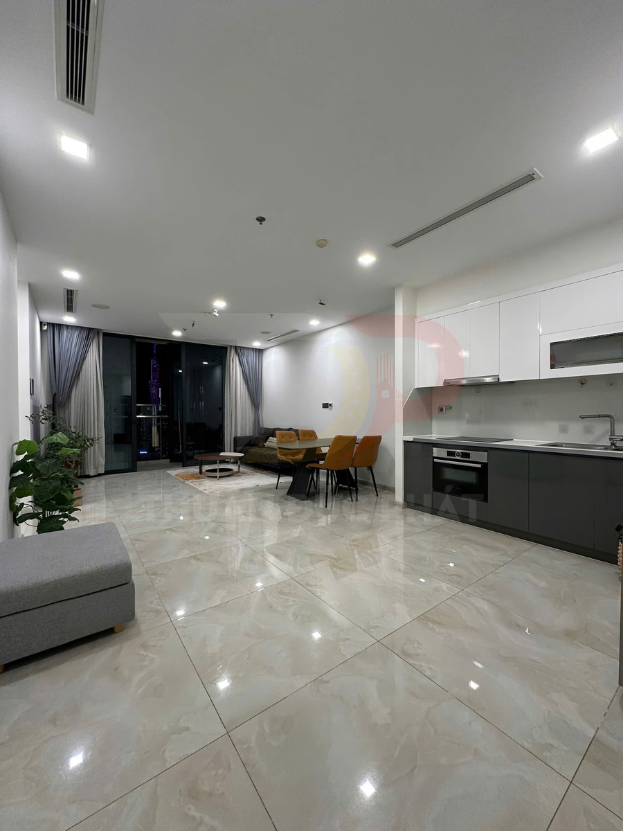Phòng khách và bếp chung cư hiện đại với sàn gạch bóng, sofa, bàn ăn và tủ bếp âm tường màu trắng xám