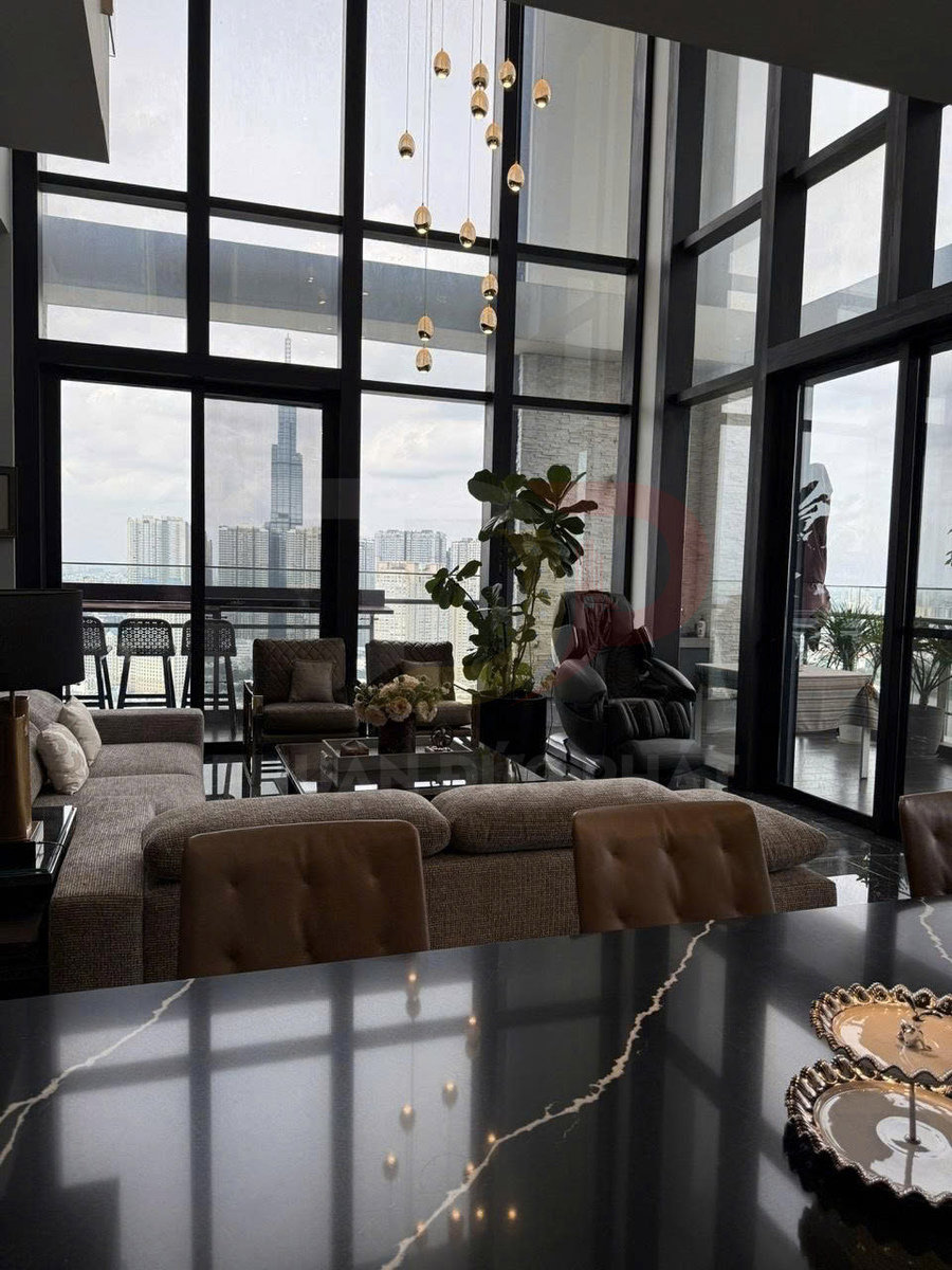 Phòng khách căn hộ cao cấp với sofa lớn, bàn đá đen vân trắng và cửa kính toàn cảnh nhìn ra thành phố