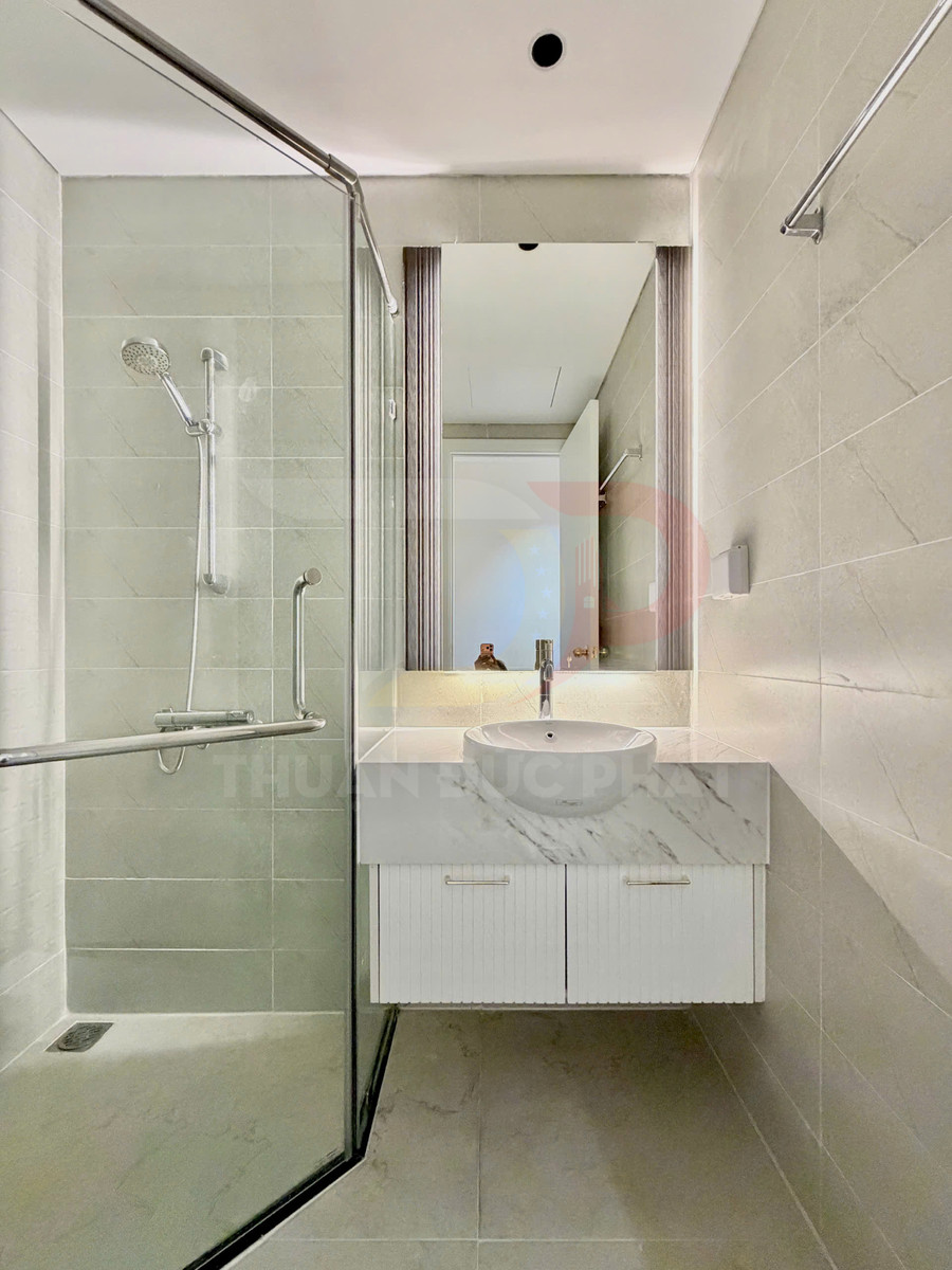 Phòng tắm hiện đại với buồng tắm kính, vòi sen treo tường và tủ lavabo đá marble trắng