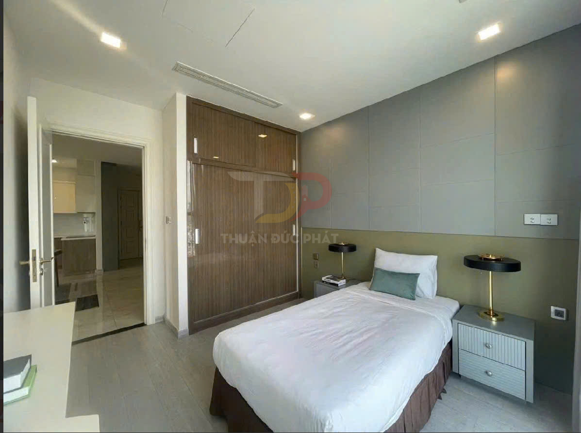 Phòng ngủ nhỏ hiện đại với giường đơn, tủ quần áo gỗ âm tường và hai tab đầu giường có đèn bàn