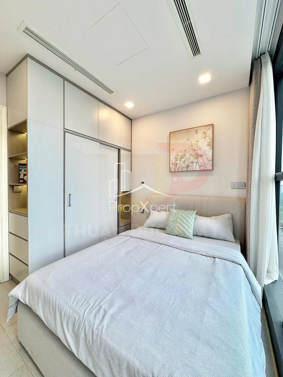 Phòng ngủ nhỏ hiện đại với giường đôi ga trắng, tủ quần áo âm tường và cửa sổ kính lớn tràn ánh sáng