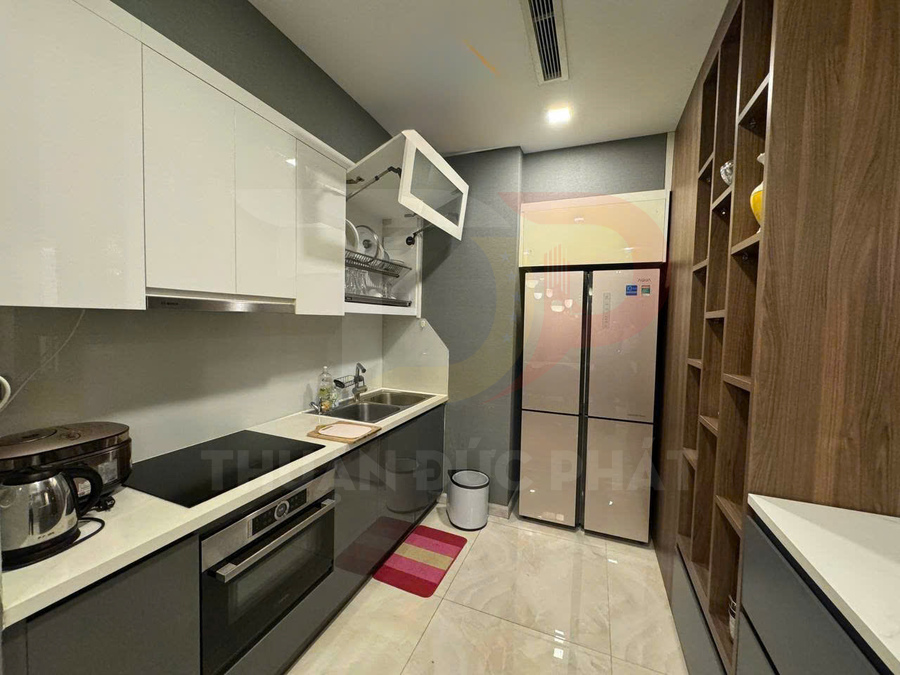 Gian bếp hiện đại với tủ bếp chữ I, bếp từ, lò nướng âm tủ và tủ lạnh lớn hai cánh