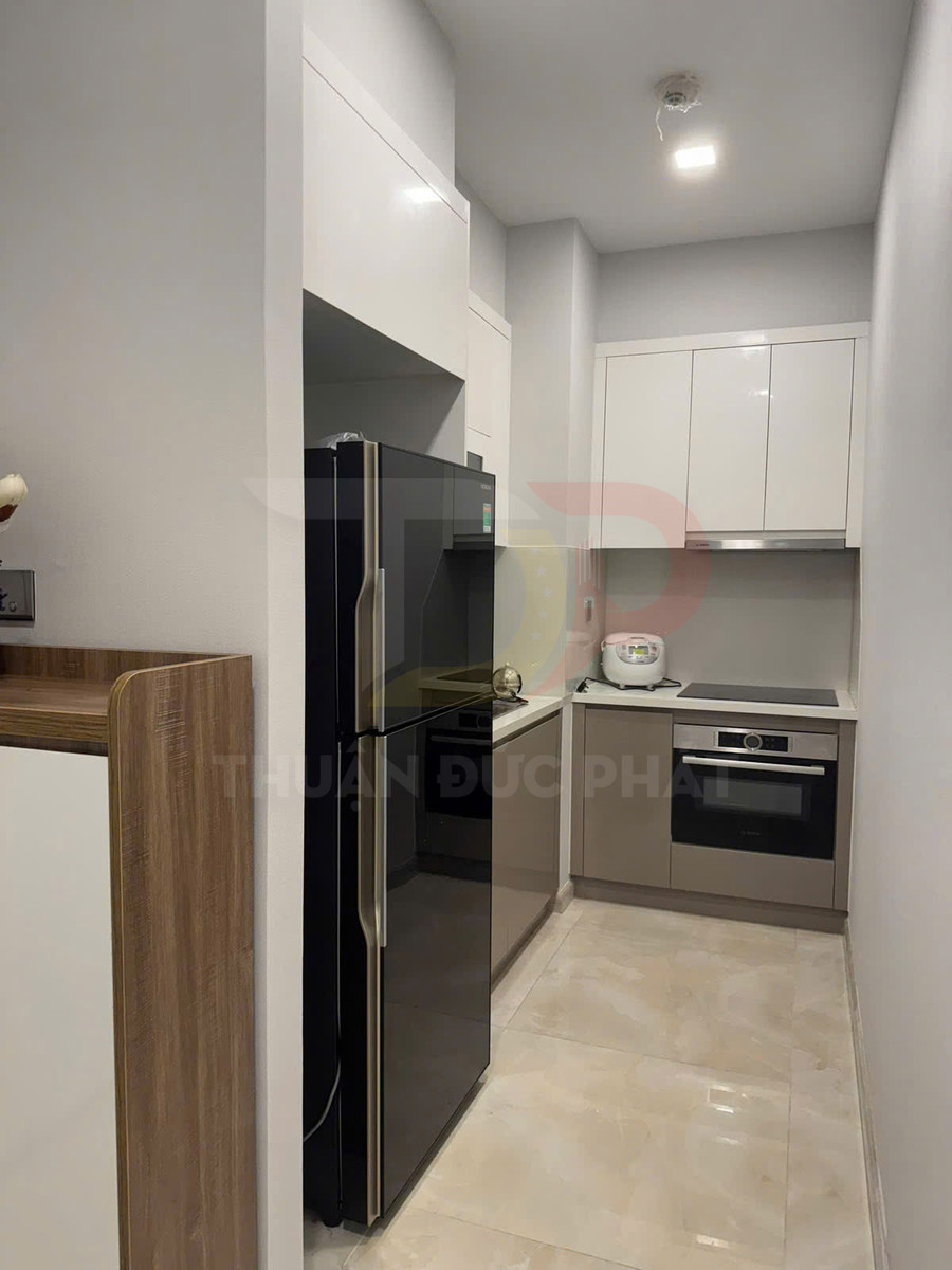 Tủ lạnh hai cánh màu đen trong căn bếp nhỏ hiện đại với tủ bếp và bếp âm tường