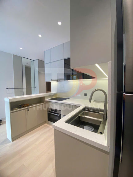 Gian bếp hiện đại nhỏ gọn với tủ bếp chữ L, bồn rửa inox và mặt bàn đá sáng màu