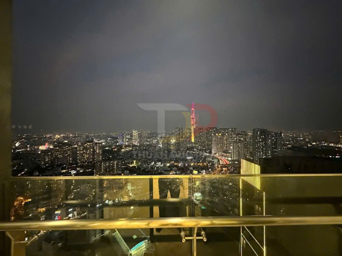 Ban công kính cường lực nhìn ra toàn cảnh thành phố với tòa nhà cao tầng sáng đèn ban đêm