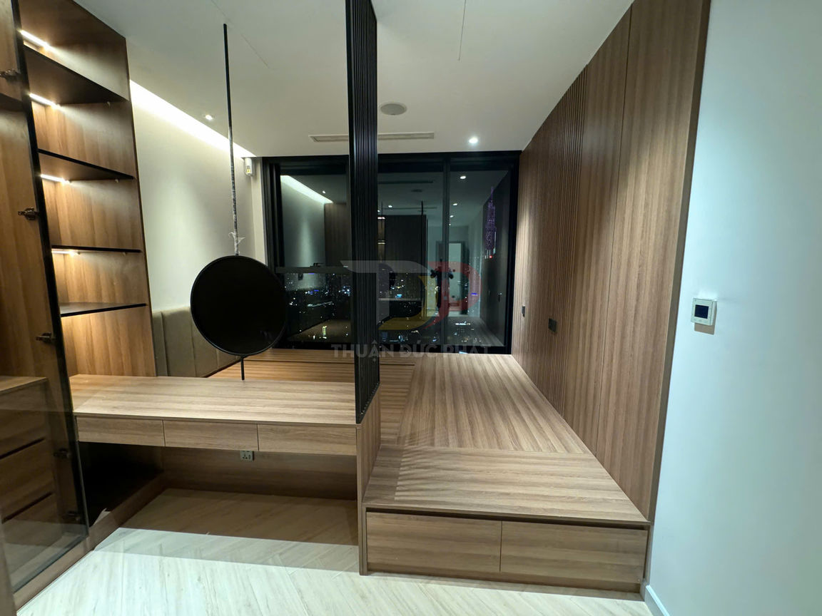 Nội thất phòng ngủ gỗ công nghiệp hiện đại với giường bục, kệ trang trí và cửa kính lớn nhìn ra thành phố