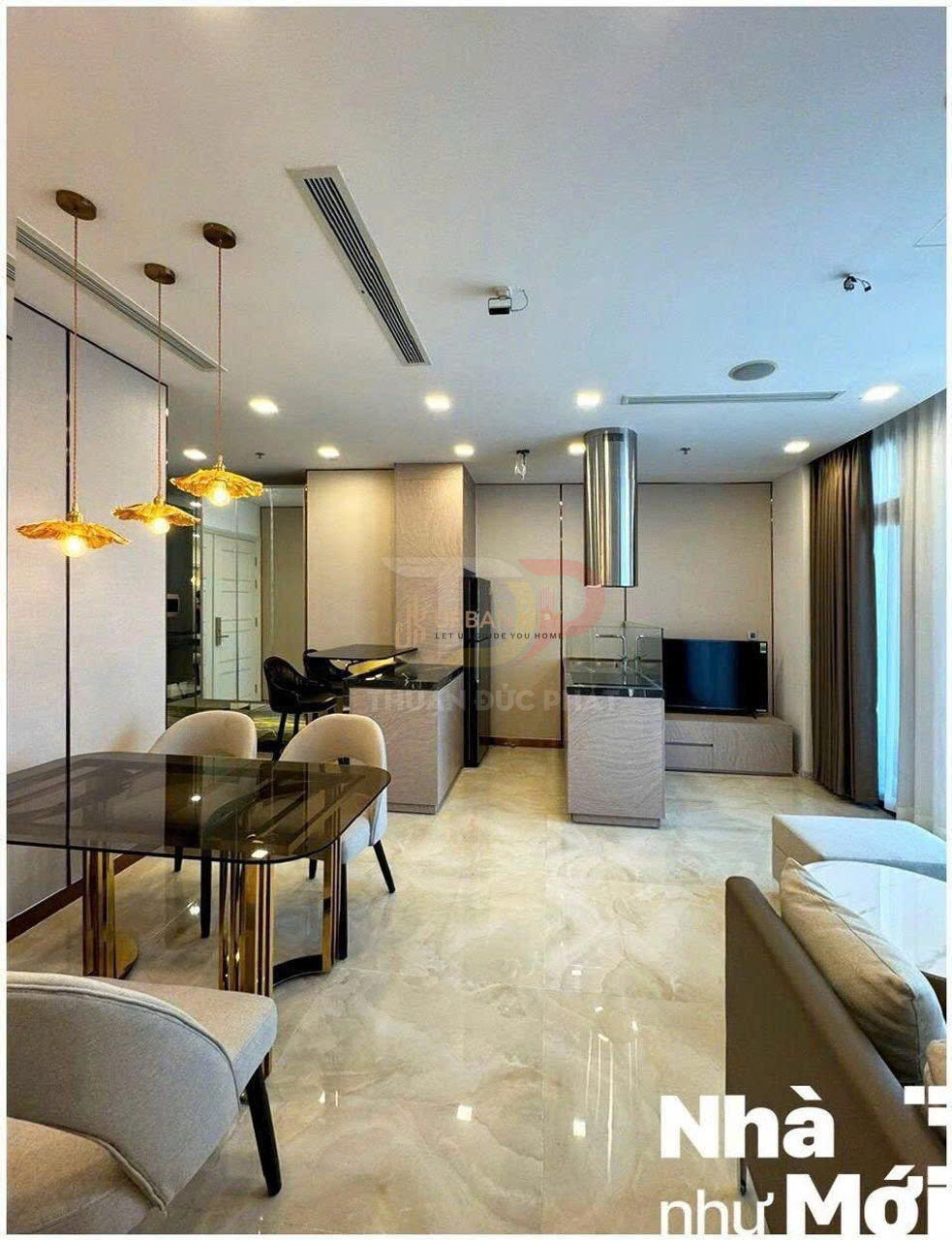 Phòng khách chung cư hiện đại với bàn ăn kính chân kim loại, ghế bọc nỉ và đèn thả trang trí sang trọng