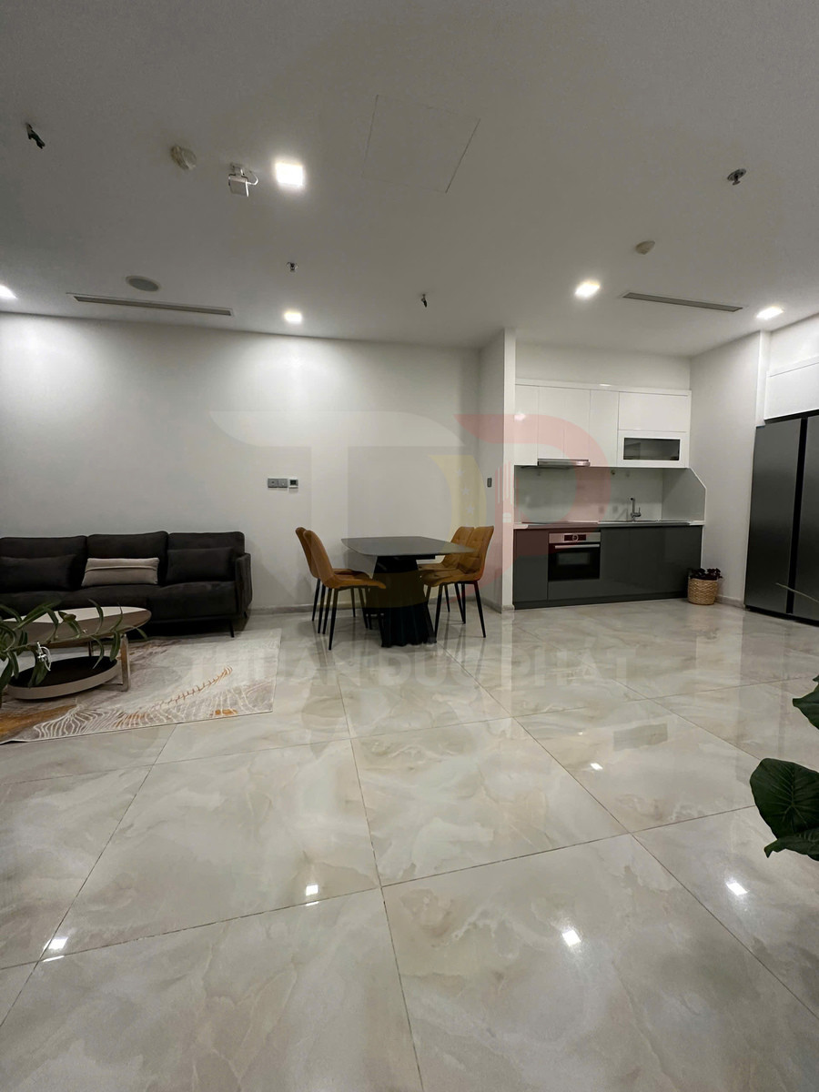 Phòng khách liền bếp hiện đại với bộ sofa, bàn ăn bốn ghế và sàn gạch bóng lớn