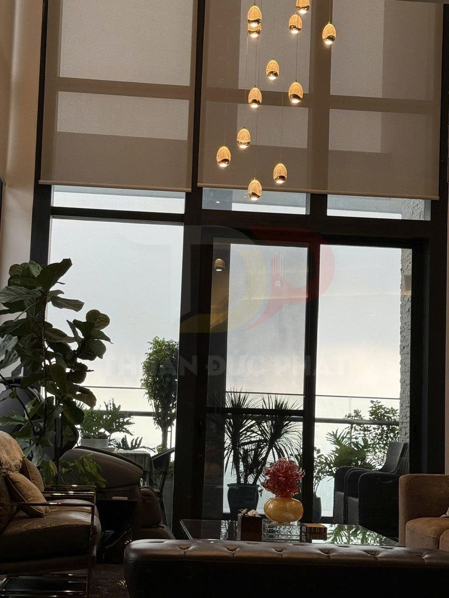 Rèm cuốn cửa sổ lớn trong phòng khách hiện đại nhìn ra ban công nhiều cây xanh