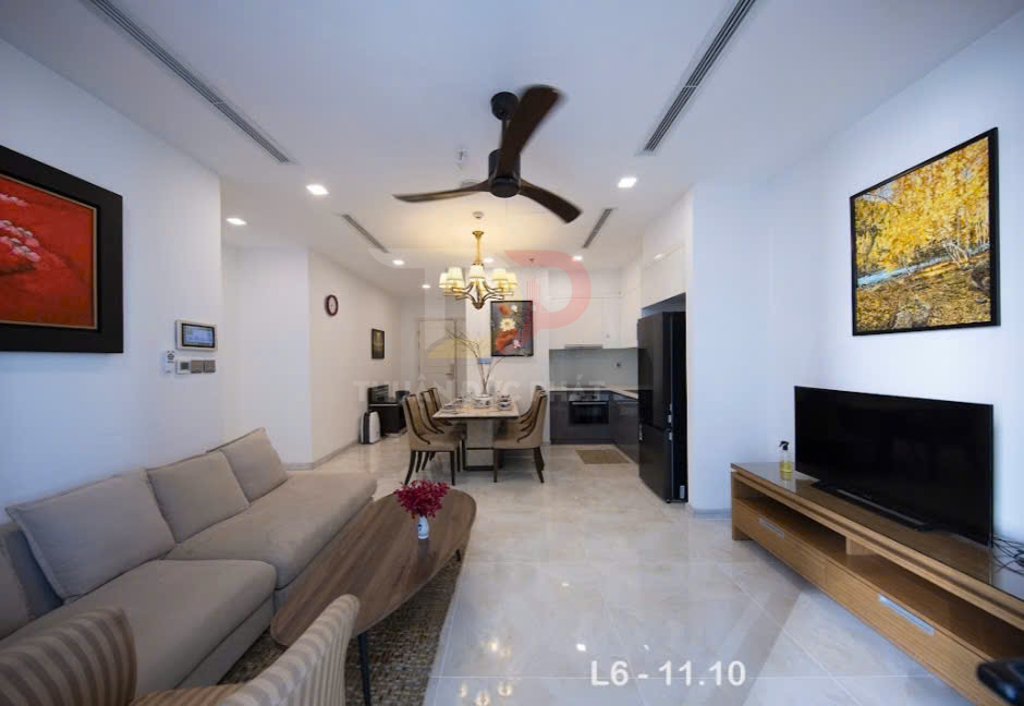 Phòng khách chung cư hiện đại với sofa, bàn gỗ, tivi màn hình phẳng và bếp liền kề