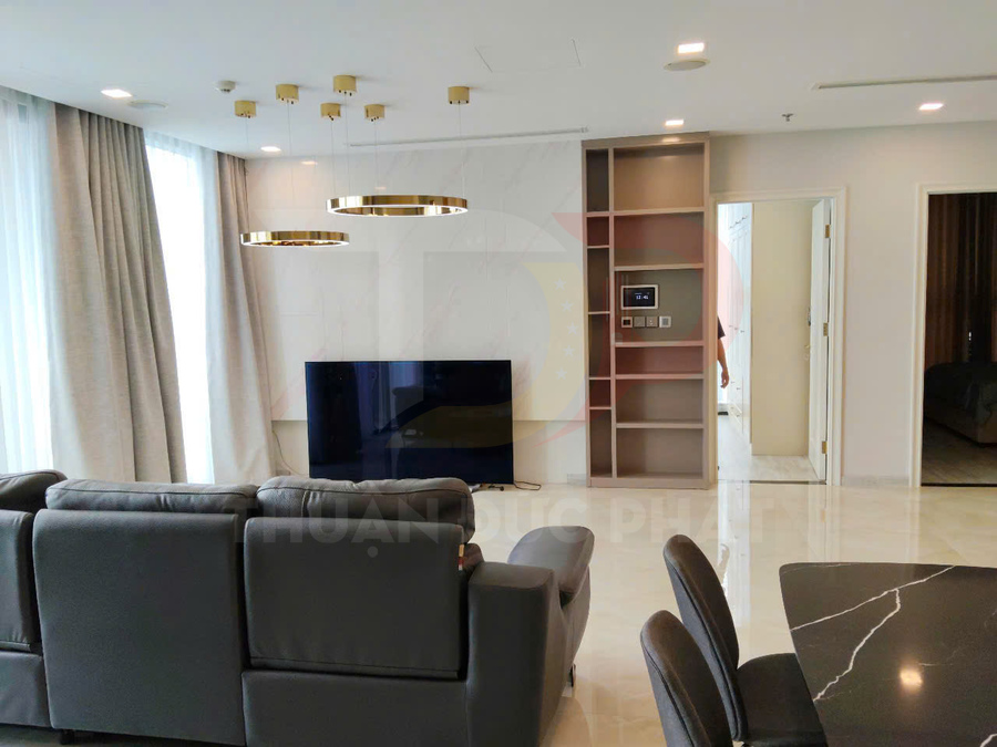 Phòng khách hiện đại với sofa da xám, tivi màn hình phẳng và đèn trần vòng tròn sang trọng