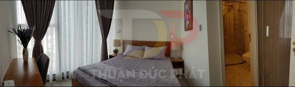 Phòng ngủ chung cư nội thất gỗ hiện đại với giường đôi cạnh cửa sổ lớn và rèm tối màu