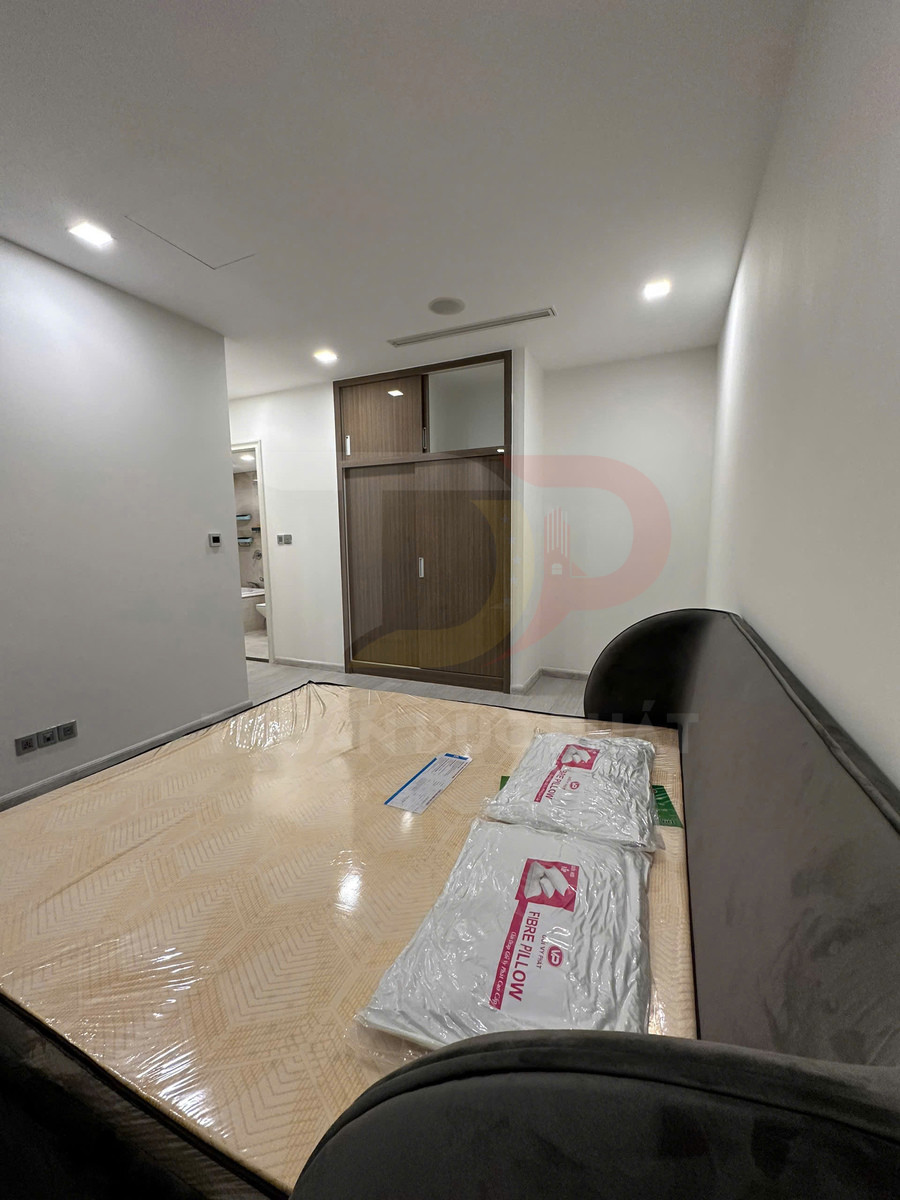 Giường ngủ mới với nệm bọc nilon và hai gối sợi nhân tạo trong phòng ngủ hiện đại
