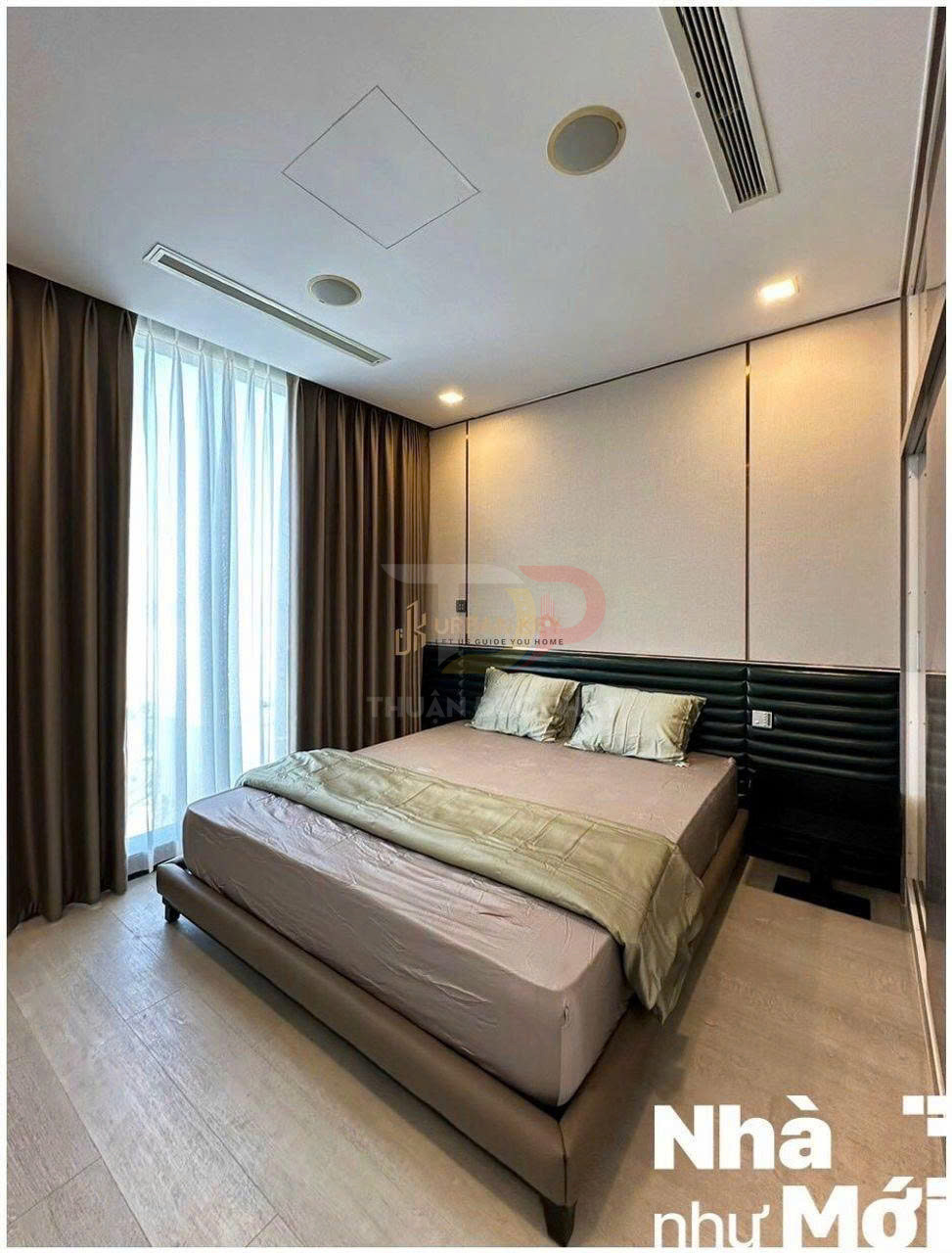 Phòng ngủ hiện đại với giường đôi bọc da, ga giường màu trung tính và rèm cửa sổ lớn đón ánh sáng tự nhiên