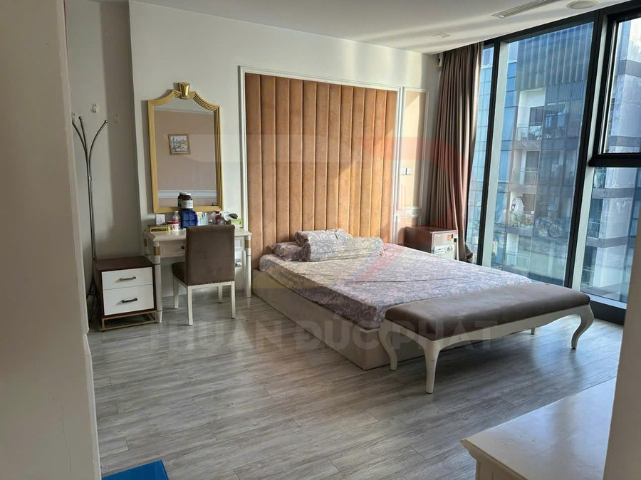 Phòng ngủ hiện đại với giường đôi bọc nệm, tab đầu giường và bàn trang điểm cạnh cửa sổ kính lớn