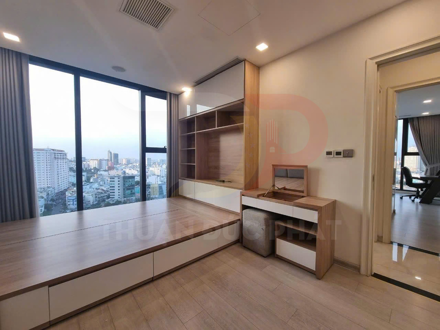 Phòng ngủ chung cư với giường gỗ liền tủ và bàn trang điểm hiện đại cạnh cửa sổ lớn view thành phố
