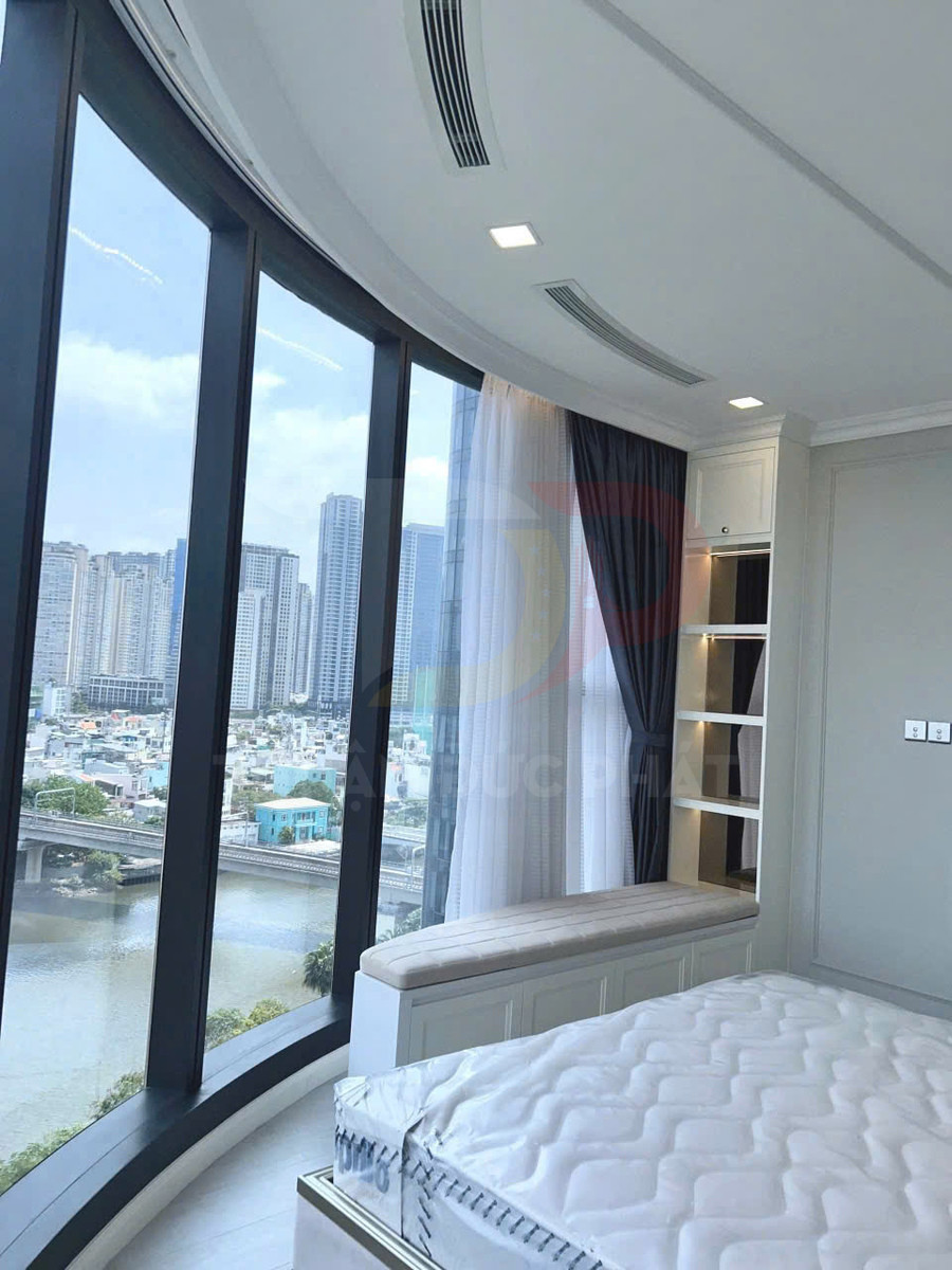 Phòng ngủ chung cư cao cấp với giường nệm mới cạnh cửa kính cong toàn cảnh sông và thành phố