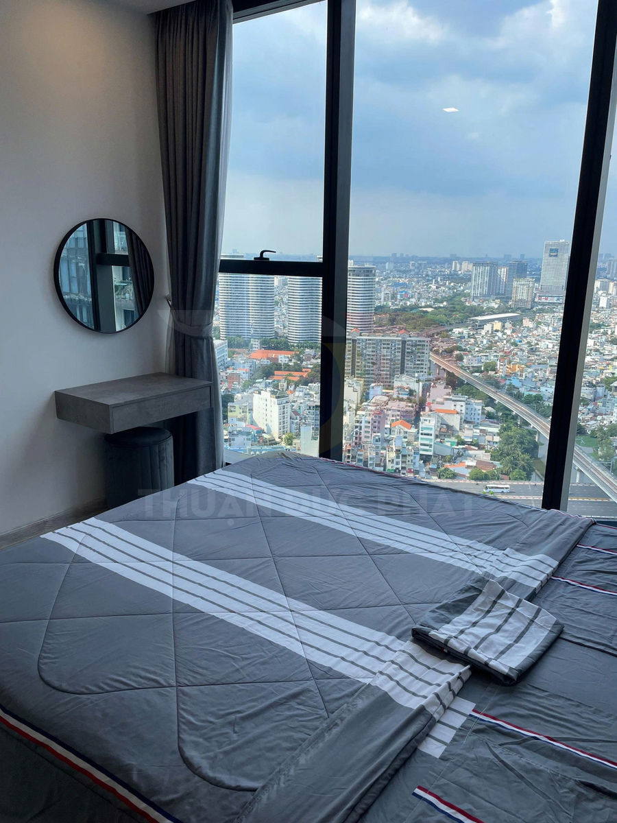 Bộ chăn ga gối màu xám kẻ sọc trên giường cạnh cửa sổ lớn view thành phố