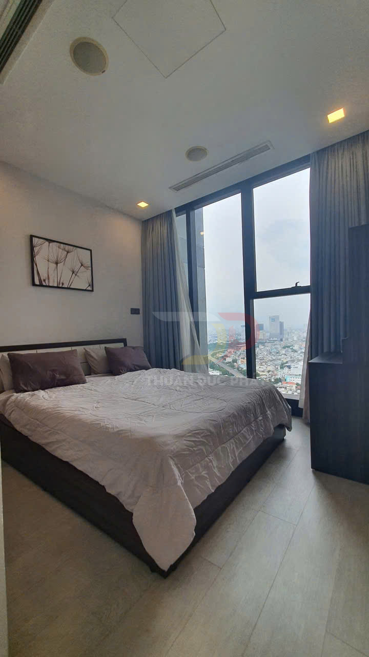 Phòng ngủ chung cư hiện đại với giường đôi cạnh cửa sổ kính lớn nhìn ra thành phố