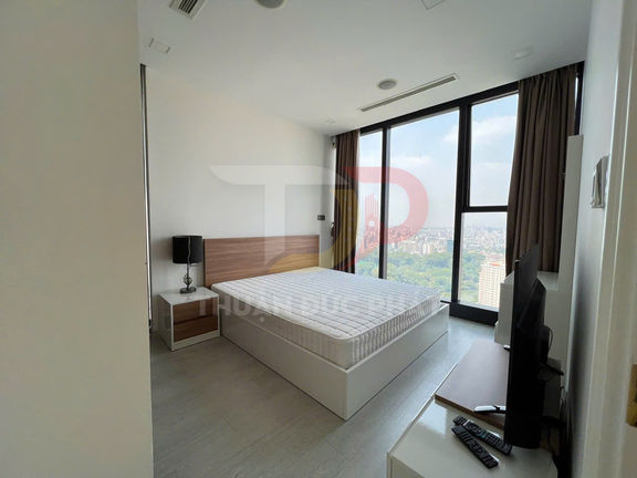 Phòng ngủ chung cư hiện đại với giường đôi, nệm trắng và cửa kính lớn nhìn ra thành phố