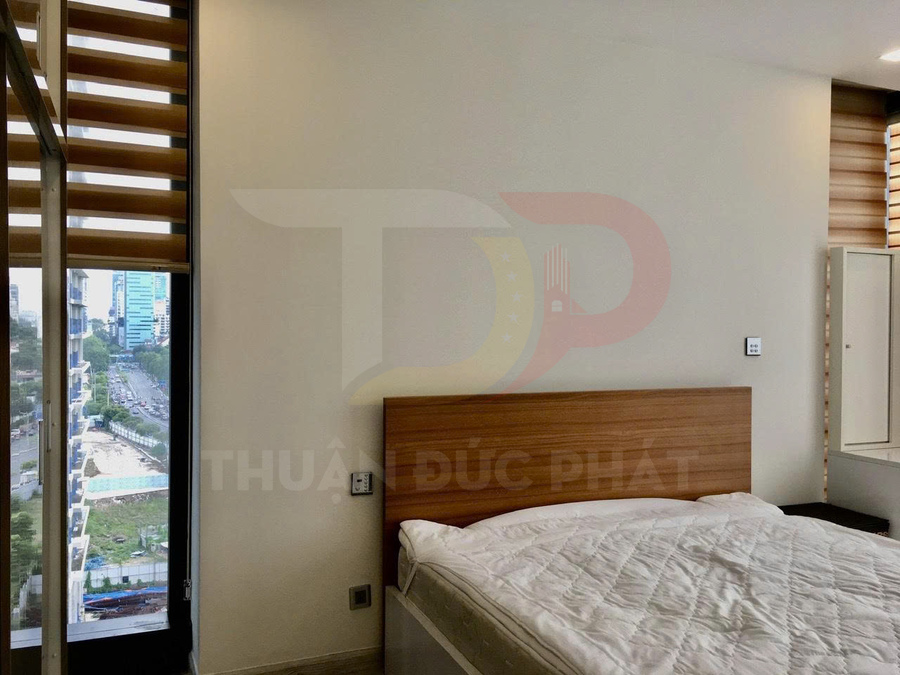 Phòng ngủ hiện đại với giường gỗ đơn giản, nệm trắng và cửa sổ lớn nhìn ra thành phố