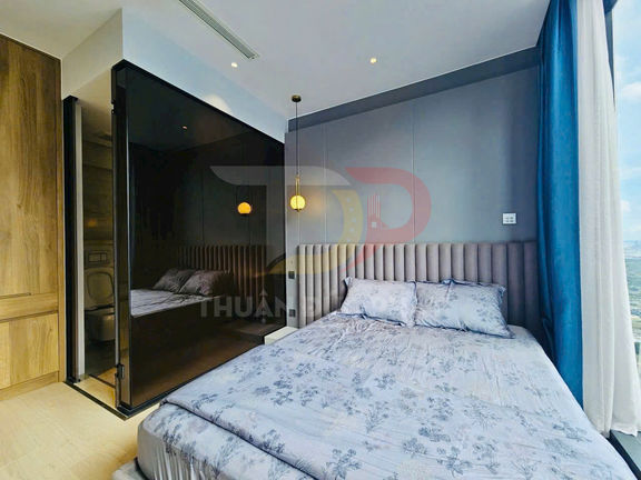 Phòng ngủ chung cư hiện đại với giường đôi ga hoa màu xám cạnh cửa sổ kính lớn view thành phố