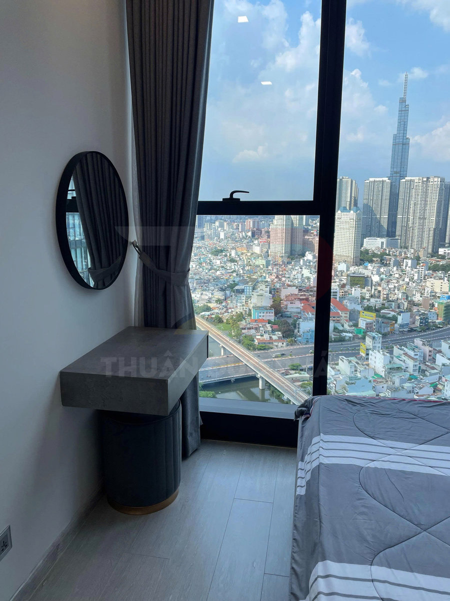 Bàn trang điểm nhỏ cạnh giường ngủ cạnh cửa sổ kính lớn nhìn ra thành phố và sông