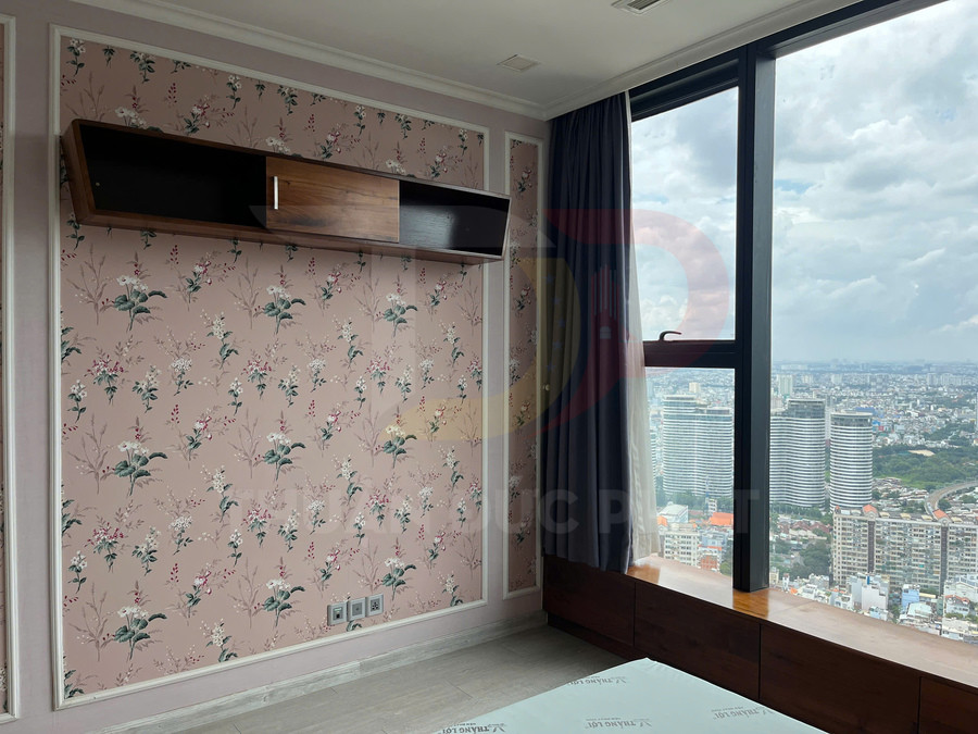 Giấy dán tường hoa màu hồng trong phòng ngủ chung cư cao tầng có cửa sổ kính lớn nhìn ra thành phố