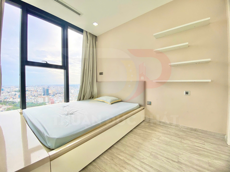 Phòng ngủ nhỏ với giường đơn cạnh cửa sổ lớn view thành phố và kệ treo tường tối giản