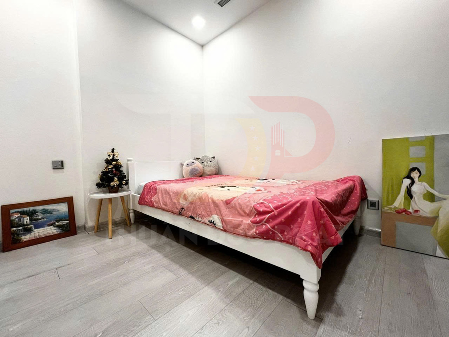 Giường ngủ đơn màu trắng với chăn hồng và gấu bông trong phòng ngủ tối giản dành cho bé gái