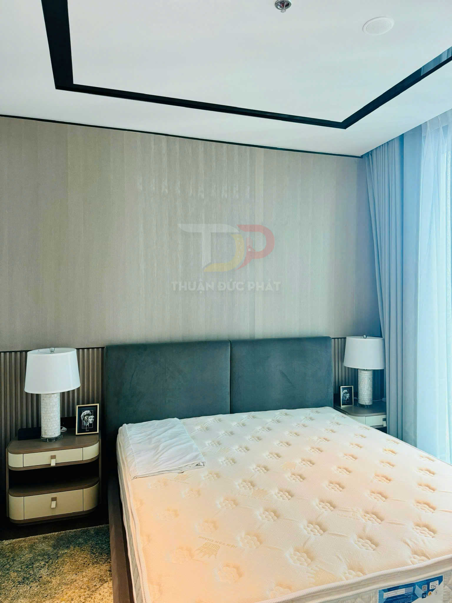 Nệm giường cao cấp màu trắng trên giường bọc nệm xám trong phòng ngủ hiện đại có hai tủ đầu giường