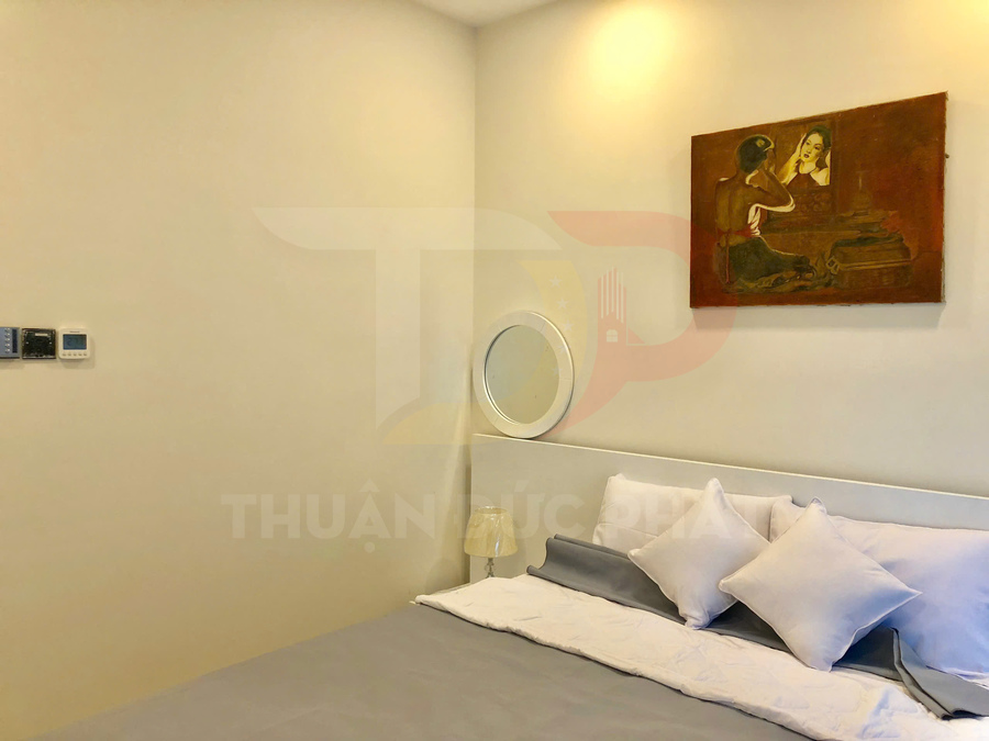 Phòng ngủ hiện đại với giường đôi ga trải màu xám trắng và tranh treo tường trang trí phía trên đầu giường