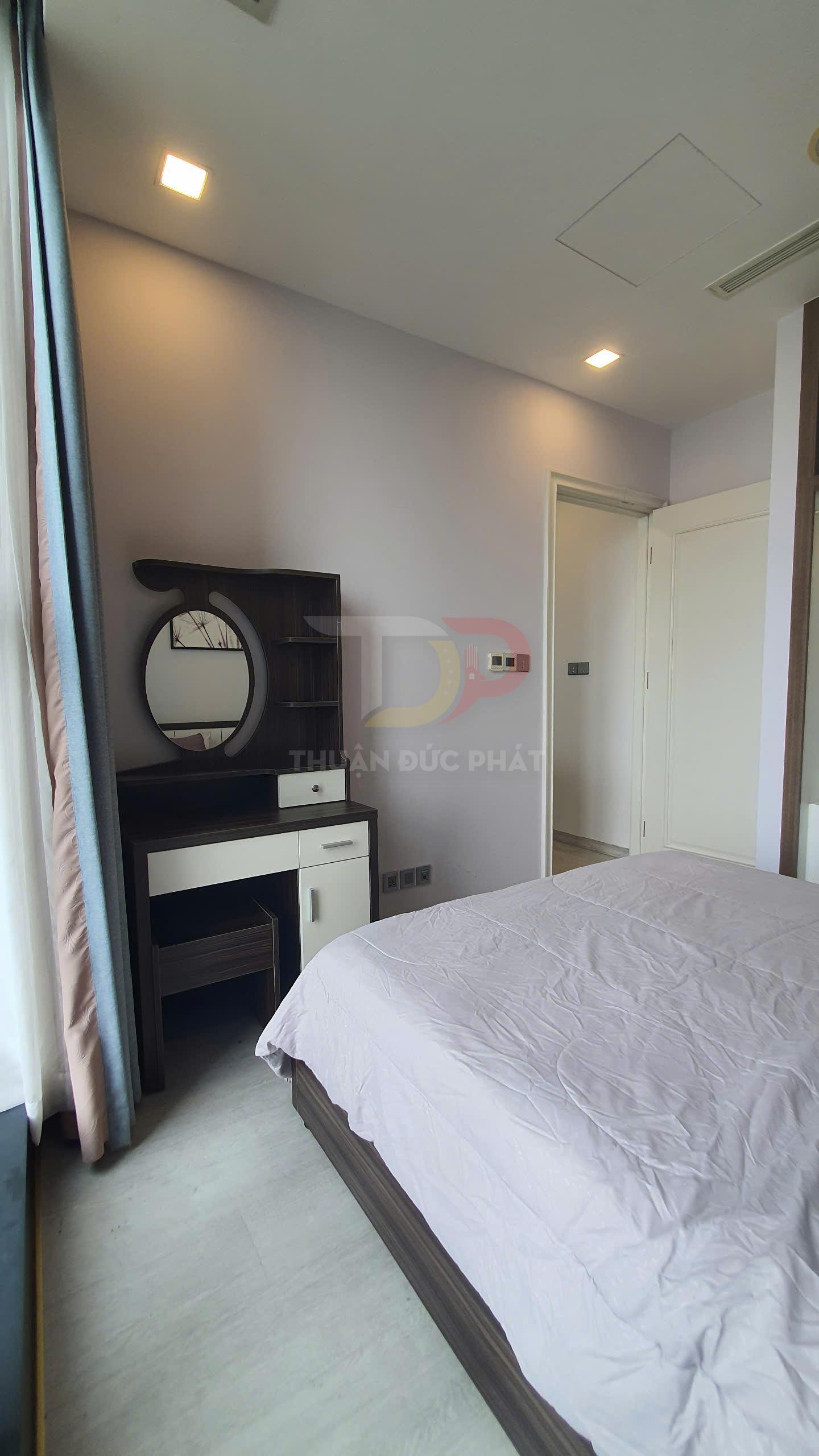 Bàn trang điểm gỗ hiện đại cạnh giường ngủ trong phòng ngủ sáng có rèm cửa sổ