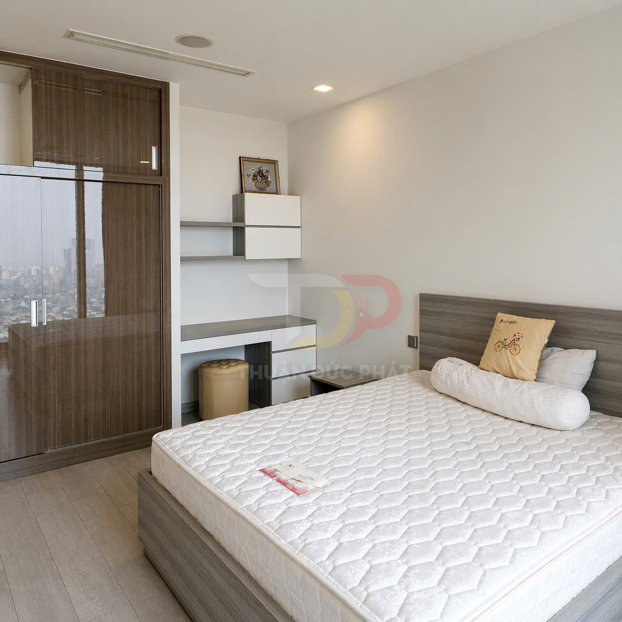 Nệm ngủ trắng trên giường gỗ trong phòng ngủ hiện đại có tủ quần áo và bàn làm việc