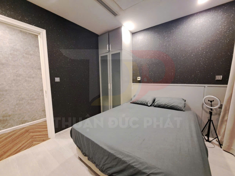 Phòng ngủ hiện đại với giường đôi ga xám, tủ quần áo cửa kính và tường màu tối sang trọng