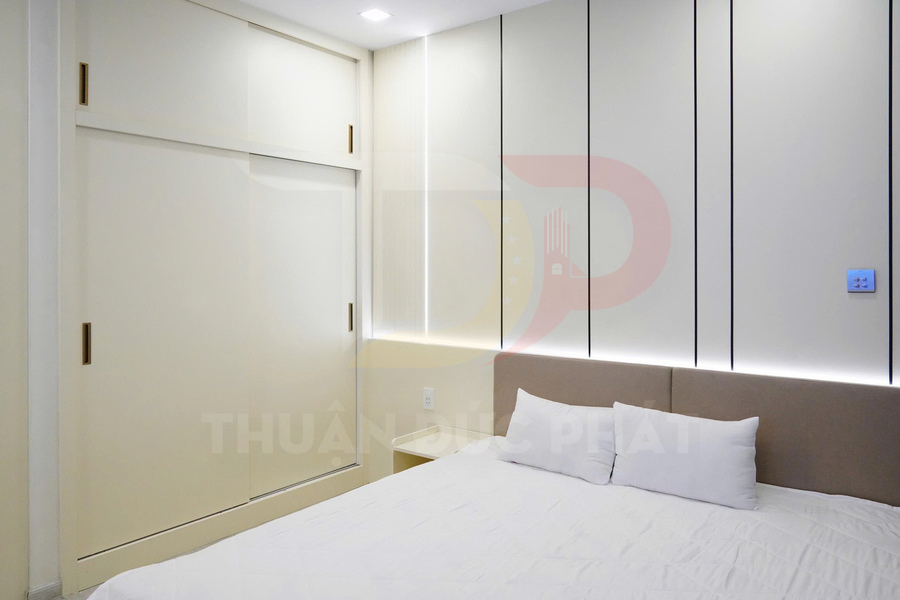 Phòng ngủ hiện đại với tủ quần áo cửa lùa màu trắng và giường bọc nệm đơn giản