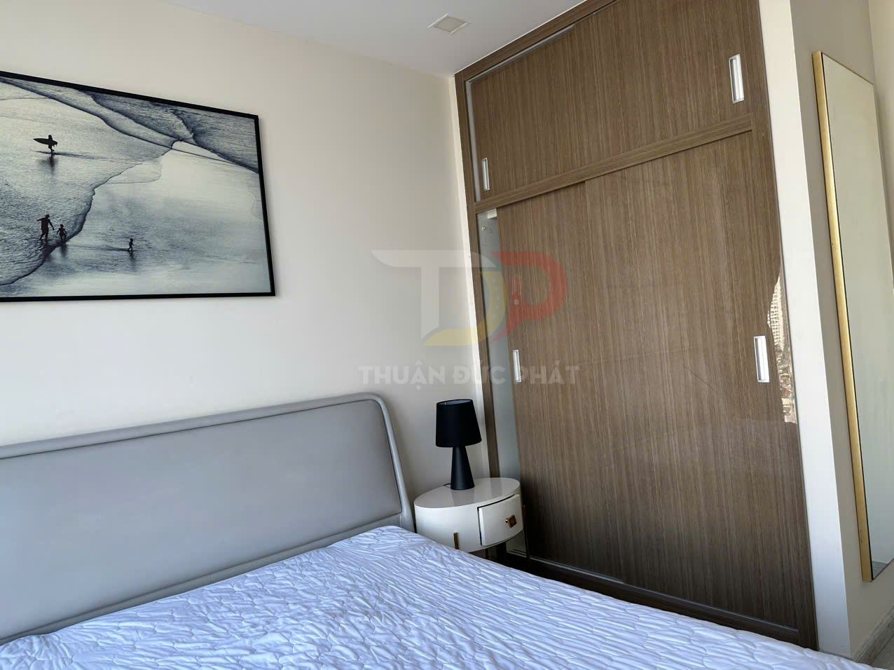 Tủ quần áo gỗ cửa lùa trong phòng ngủ hiện đại với giường bọc nệm và bàn đầu giường nhỏ